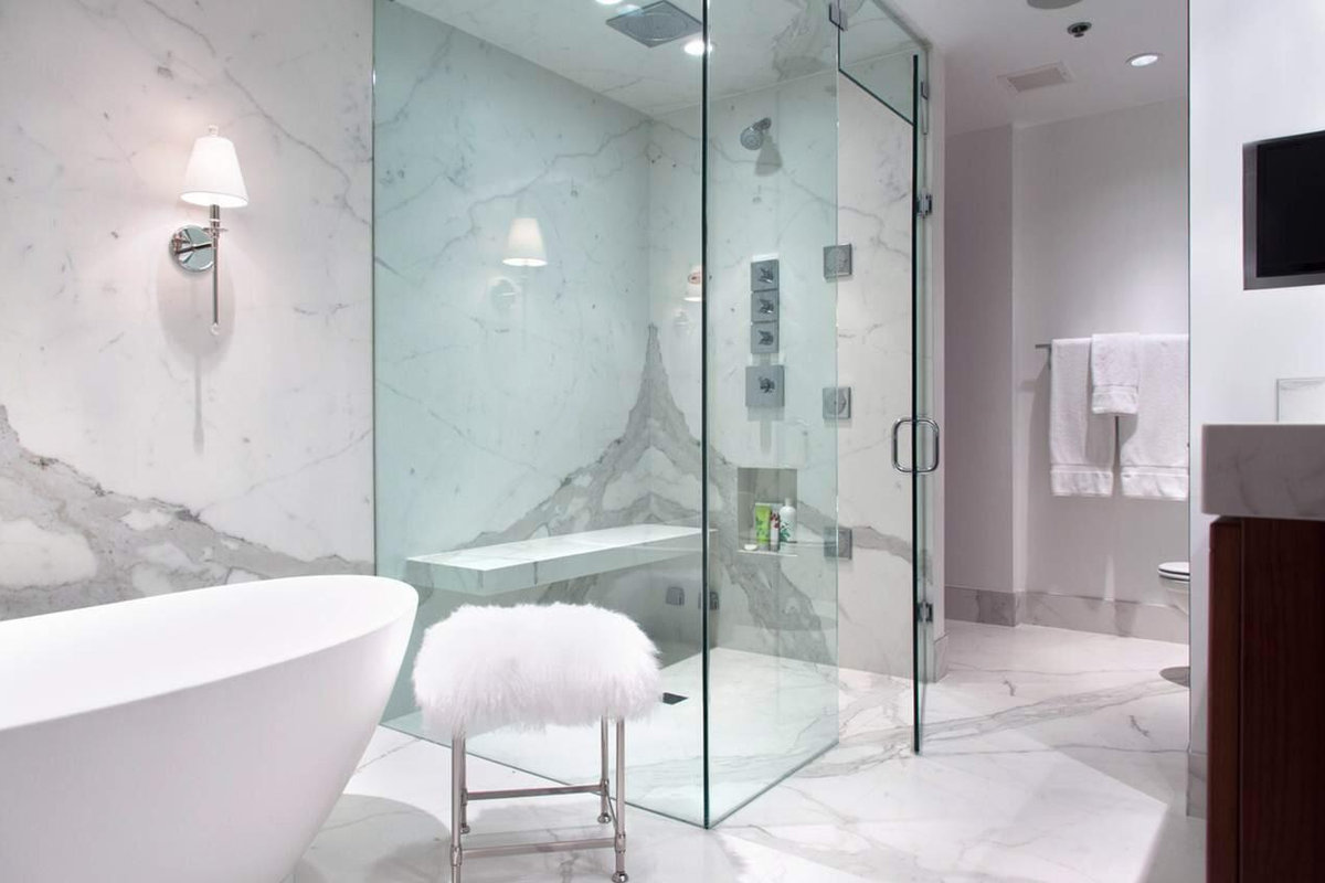Porcelain Slabs — master bathroom with freestanding tub, marble walls, and glass shower enclosure. Boston area.
