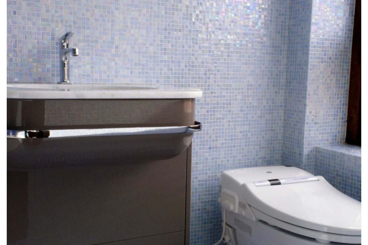 Loon House — bathroom with iridescent glass mosaic tile walls, sleek vanity.